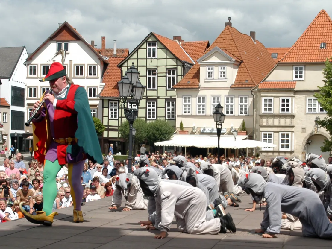 Der Rattenf&auml;nger spielt auf einer Fl&ouml;te und die kleinen Ratten folgen ihm.