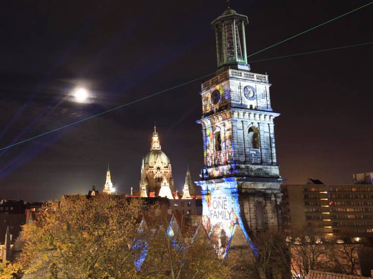 Kirche angestrahlt mit den Worten "We are all one family"